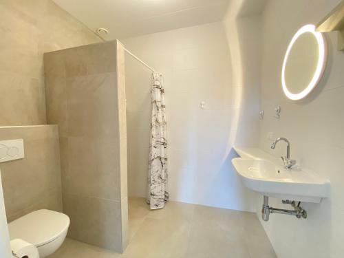 Un baño blanco con inodoro y lavabo. en Previnaireweg 30, en Callantsoog