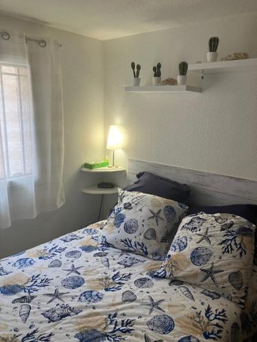un lit avec des draps et des oreillers bleus et blancs dans l'établissement Maison du rivage bleu, à Gruissan