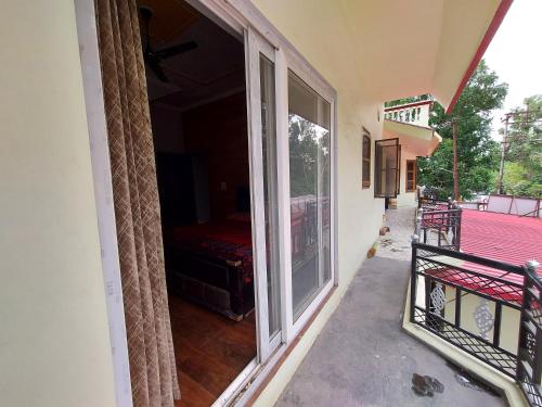 a balcony with a sliding glass door to a bedroom at AK Homestay in Dehradun