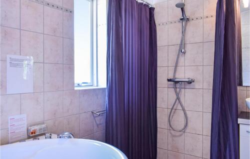 a bathroom with a shower with a purple shower curtain at Holiday Home Skibby 41 in Brønde