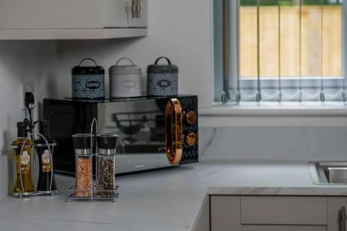 a kitchen with a counter with spices and a microwave at Free Parking, Families, Short Stays - Durham in Durham