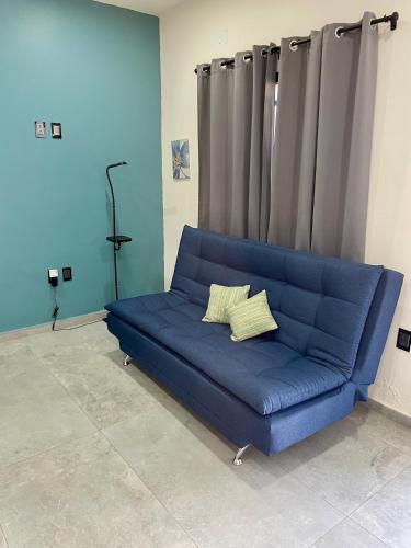 a blue couch with two pillows on it in a room at Departamento privado con estacionamiento in Tequila