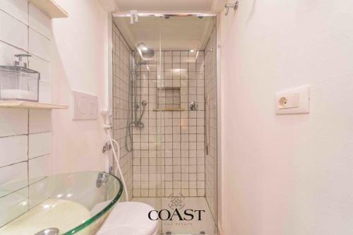 a bathroom with a glass sink and a shower at Family Flat - Casa vacanza ideale per famiglie in Olbia