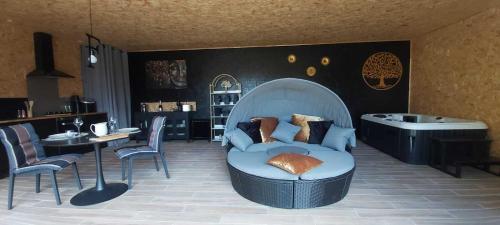 a living room with a blue couch and a tub at Le Clos FMR Insolite - "F"anny Carcassonne in Malves-en-Minervois