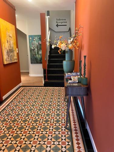 a hallway with orange walls and a tile floor at Südstadt-Hotel Wilhelmshaven in Wilhelmshaven