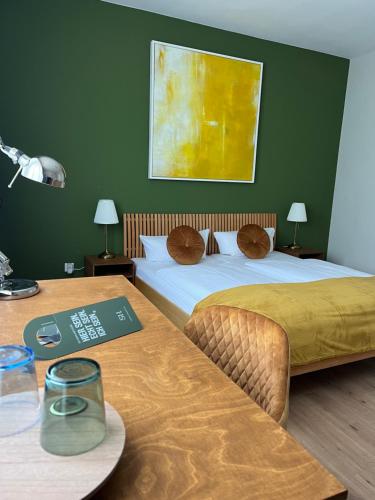 two beds in a room with two tables and a table with a table at Südstadt-Hotel Wilhelmshaven in Wilhelmshaven