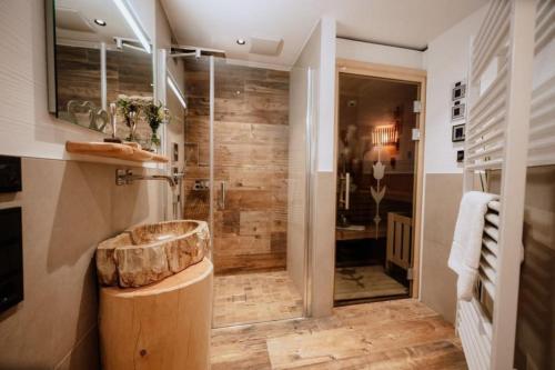 ノイキルヒェン・アム・グロースヴェンエーディガーにあるNationalpark Chalet Tulpspitzeの木製の洗面台と大きなシャワーを備えたバスルーム