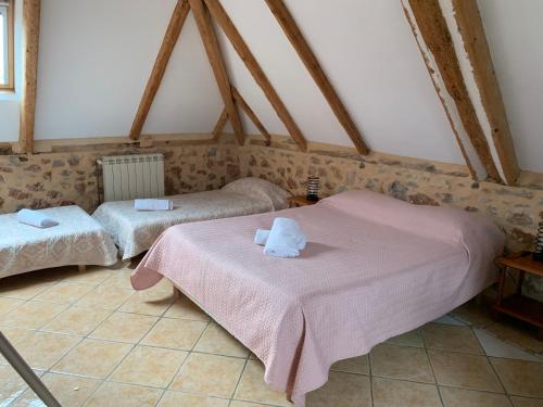 une chambre avec deux lits avec des serviettes dessus dans l'établissement Café de la Place Gîte & Chambres d'hôtes 