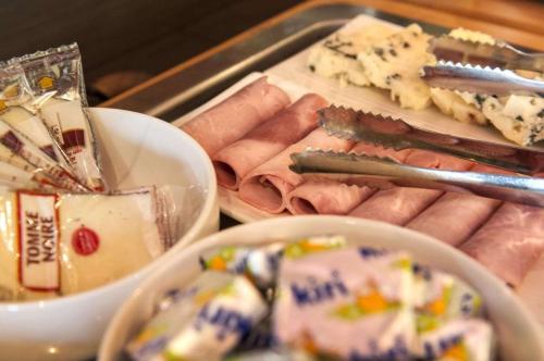 a tray filled with different types of meats and cheese at Brit Hotel Confort Montauban in Montauban