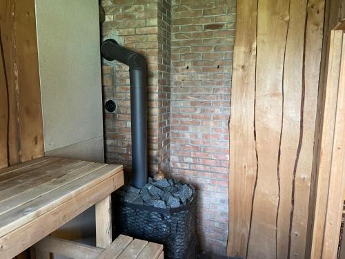 a black pipe is on the side of a brick wall at Petsi suvila in Kuru