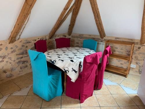 une salle à manger avec une table et des chaises dans une pièce dans l'établissement Café de la Place Gîte & Chambres d'hôtes 