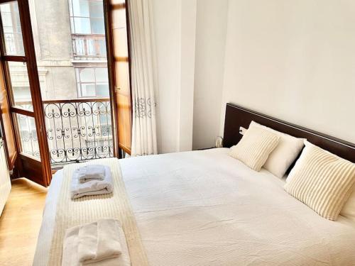 a bedroom with a bed with two towels on it at Apto La Muralla Centro - Playa in Gijón