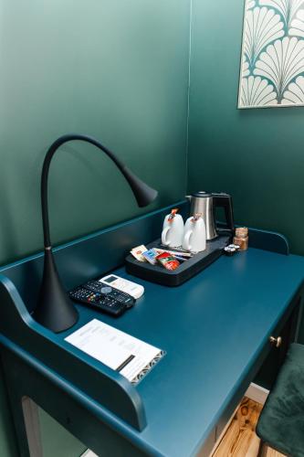 a blue desk with a lamp on top of it at Elegant Apartments in Poznań
