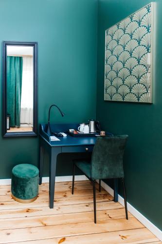a blue desk with a chair and a mirror at Elegant Apartments in Poznań