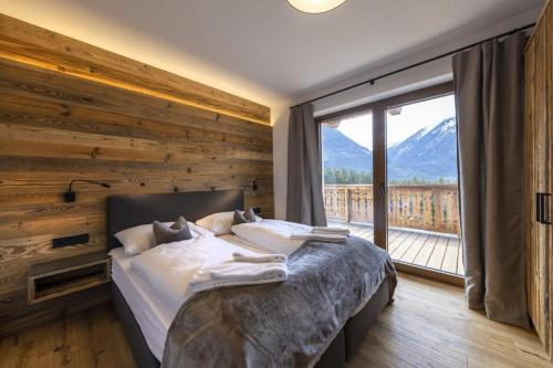a bedroom with a bed and a large window at Nationalpark Chalet Hoher Sonnblick in Neukirchen am Großvenediger