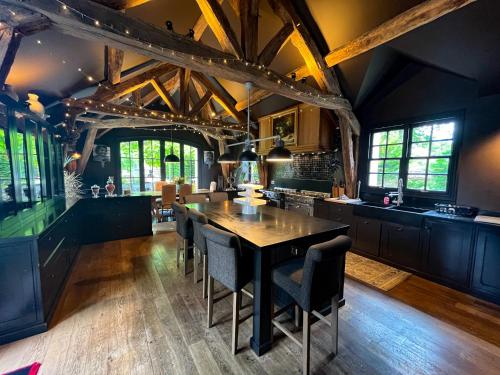 une grande cuisine avec une table et des chaises en bois dans l'établissement Propriété de charme avec SPA au cœur de Barbizon.La Barbizonaise, à Barbizon