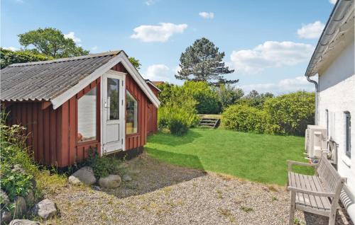 a red shed with a bench next to a yard at 1 Bedroom Cozy Home In Mesinge in Mesinge