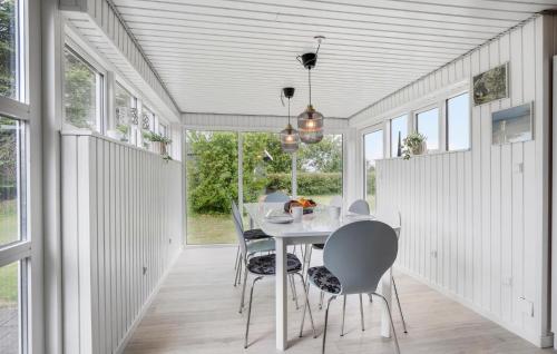 a dining room with a table and chairs and windows at 4 Bedroom Cozy Home In Middelfart in Middelfart