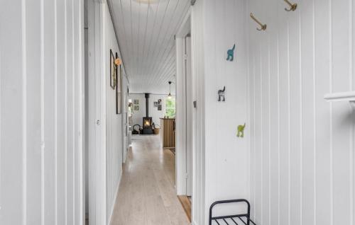 a hallway of a house with white walls and a chair at 4 Bedroom Cozy Home In Middelfart in Middelfart