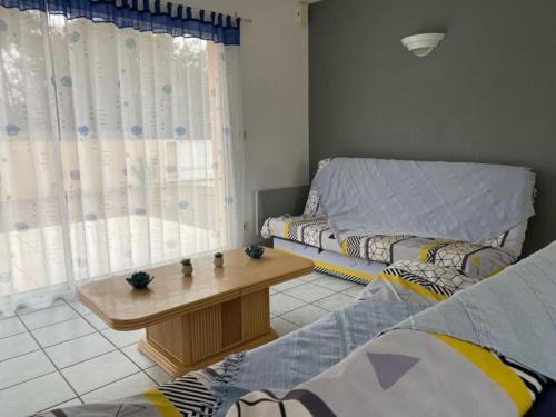 un salon avec un canapé et une table dans l'établissement Villa proche océan à Montalivet les Bains, à Vendays-Montalivet