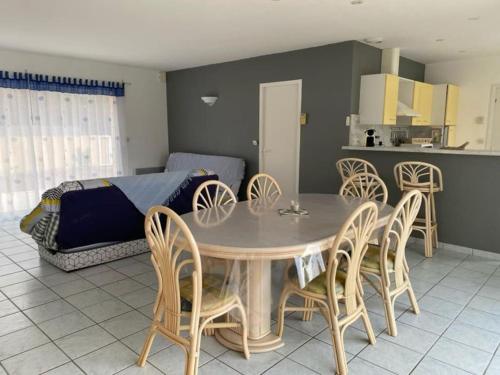 une salle à manger avec une table et des chaises dans l'établissement Villa proche océan à Montalivet les Bains, à Vendays-Montalivet