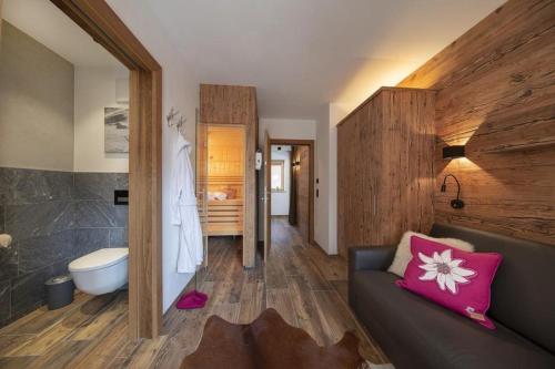 a living room with a couch and a bathroom at Nationalpark Chalet Rosenspitze in Neukirchen am Großvenediger