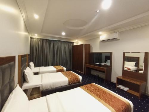 a hotel room with two beds and a mirror at Al Masem Serviced Apartments - Al Olaya - Exit 5 in Riyadh