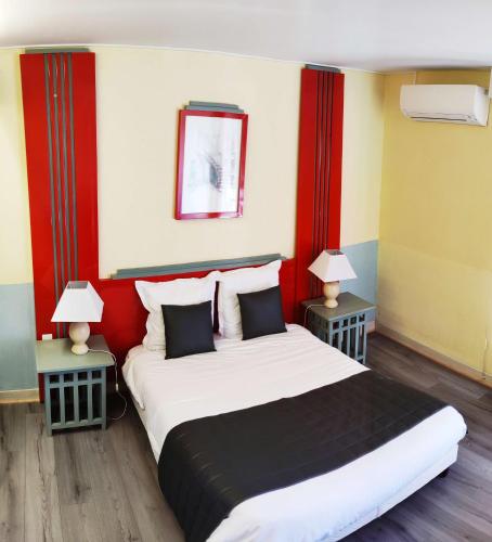 a hotel room with a large bed with two lamps at Garden & City Capvern-les-Bains in Capvern