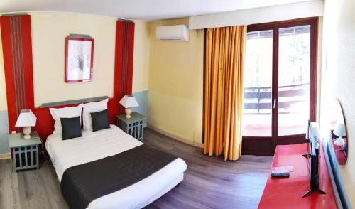 a hotel room with a bed and a television in it at Garden & City Capvern-les-Bains in Capvern