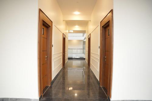 a hallway with wooden doors and tile floors at Sarvam Residency in Sāgar