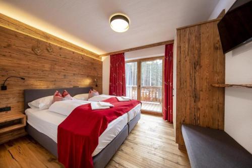 a bedroom with two beds in a room with wooden walls at Nationalpark Chalet Säulspitze in Neukirchen am Großvenediger