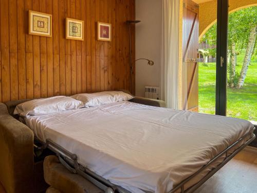 a bed in a room with a large window at Val de Llous II 39 in Sainte-Léocadie