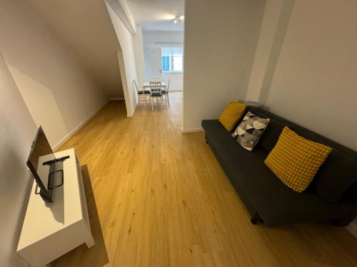 a living room with a black couch and a table at Cardigos Village Apartments in Mação