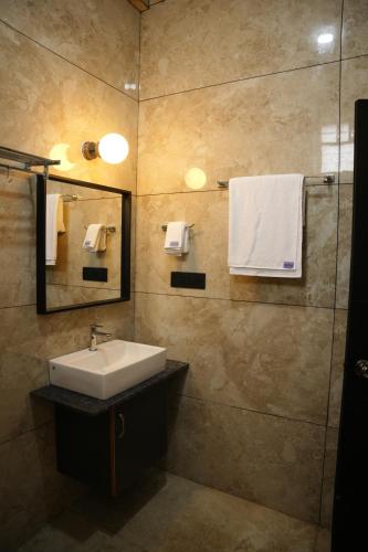 a bathroom with a sink and a mirror at Sarvam Residency in Sāgar
