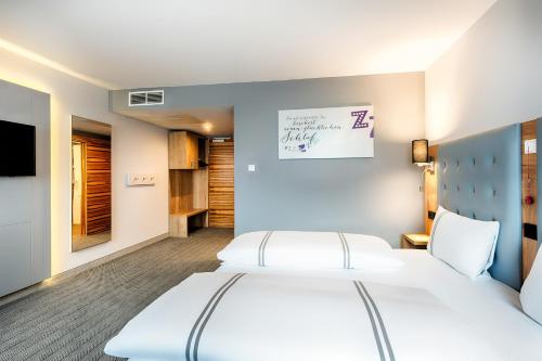 a bedroom with two beds and a tv at Premier Inn Lindau in Lindau