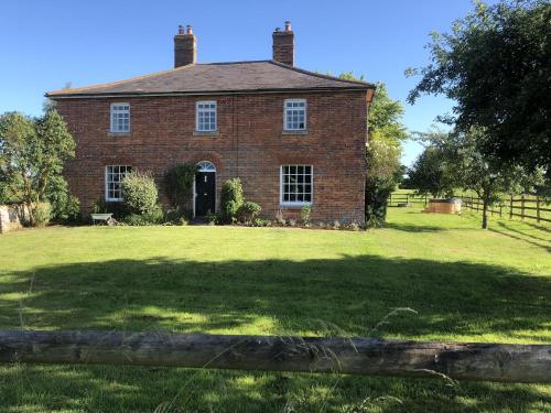 an old red brick house with a large yard at Mill Farm House in Devizes