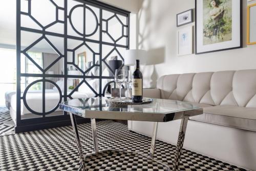 a glass table with a bottle of wine on it in a living room at Chamberlain West Hollywood in Los Angeles
