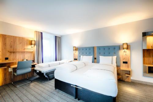 a hotel room with a large bed and a desk at Premier Inn Lindau in Lindau