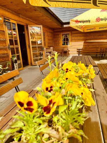 a wooden table with yellow flowers on top of it at Noclegi Przycup w Dolinie in Janowice Wielkie