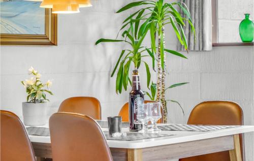 a dining room table with a bottle of wine and a plant at Holiday Home Alfedalen in Kalundborg