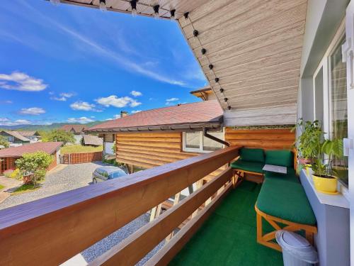 a balcony with green chairs on a house at Три-О Апартаменти з видом на гори, максимум для 4 гостей, 15 хв від центру in Slavske