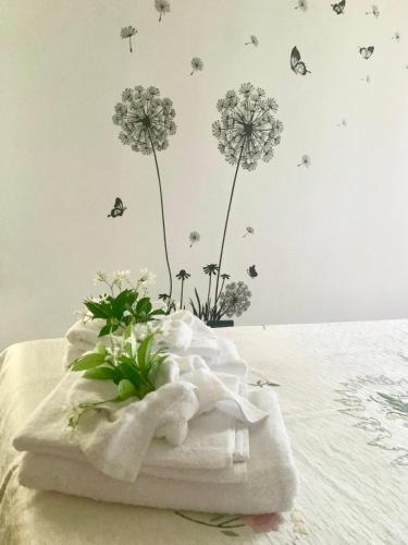 a white towel with flowers and butterflies on a bed at Castelletto in Castello dʼAviano