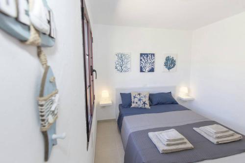 a small bedroom with a bed and two pictures on the wall at Casita Del Sol in Caleta De Fuste