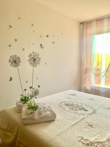 a bedroom with a bed with flowers and butterflies on the wall at Castelletto in Castello dʼAviano