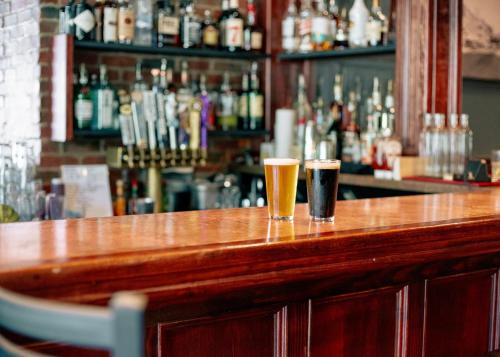 two glasses of beer sitting on a bar at Hotel St. Michael, BW Premier Collection in Prescott