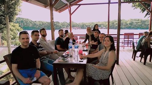 a group of people sitting at a table on a deck at Olala Bungalows and Restaurant in Sabong