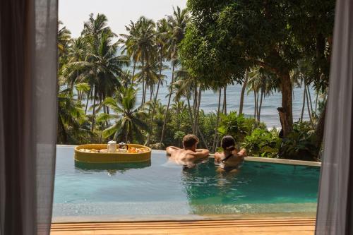a group of people in a swimming pool at Diviya Villa - Madiha Hill in Madihe East