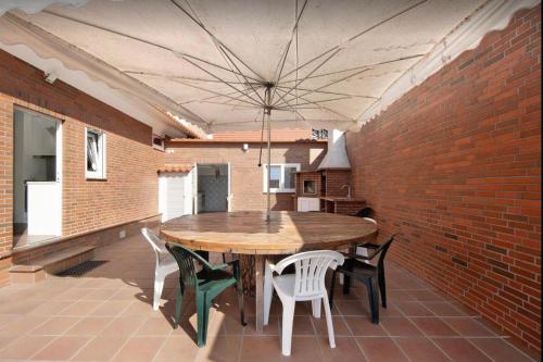 a wooden table and chairs in a room with a brick wall at Pinheiro Manso in Apúlia