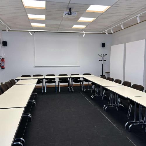 a conference room with tables and chairs and a whiteboard at BRIT HOTEL & SPA Le Roc au Chien in Bagnoles de l'Orne