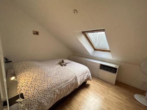 une chambre mansardée avec un lit et une fenêtre dans l'établissement Le Square : appartement climatisé en centre ville, à Poitiers